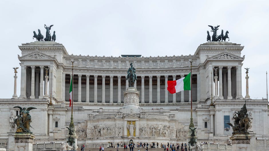 The iconic Vittoriano monument in Rome featuring Italian flags and rich architectural details.